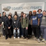Y.A.L.L. students gather in front of the sign at Loaves and Fishes after serving meals.