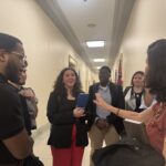 Laura Peralta-Schulte NETWORK's Senior Director of Public Policy and Government Relations gathers Y.A.L.L. students in a semi-circle to debrief a congressional office visit.