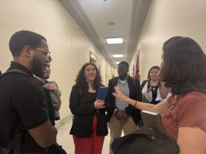 Laura Peralta-Schulte NETWORK's Senior Director of Public Policy and Government Relations gathers Y.A.L.L. students in a semi-circle to debrief a congressional office visit.