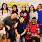 The 11 Y.A.L.L. students gather in front of the NETWORK sign for a photo.