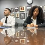 Kaila and Jonathan sit at a glass table in a congressional office while speaking during a meeting.