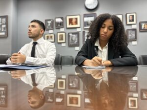 Kaila and Jonathan sit at a glass table in a congressional office while speaking during a meeting.