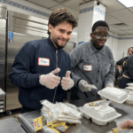 Steven left and Axl right smile as they bag hot meals for those in need,
